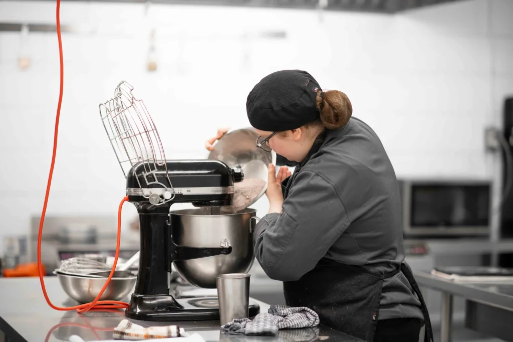 Élève en formation en pâtisserie préparant une recette avec un batteur professionnel à Laval